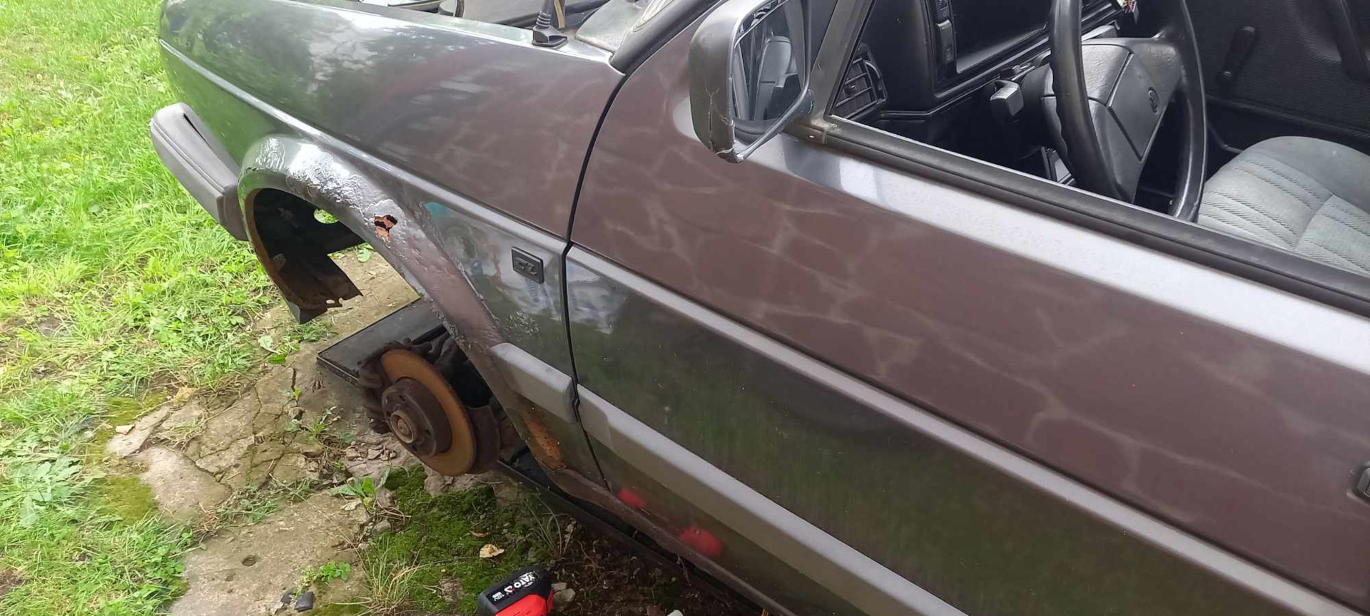 Zdjęcie podczas remontu, zdemontowane przednie lewe koło i widoczna tarcza hamulcowa