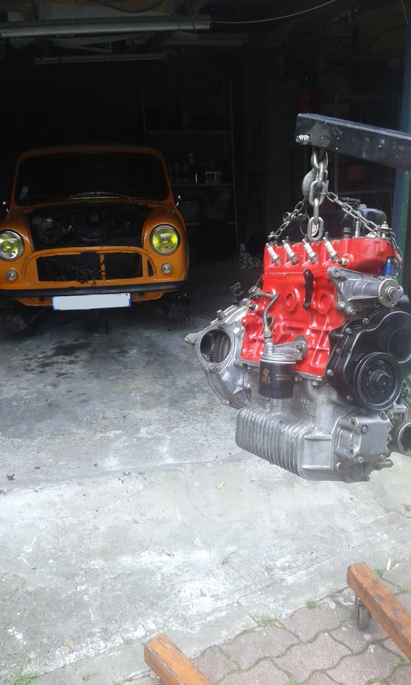 Silnik podwieszony na żurawiu do silników, w tle Austin Mini Cooper