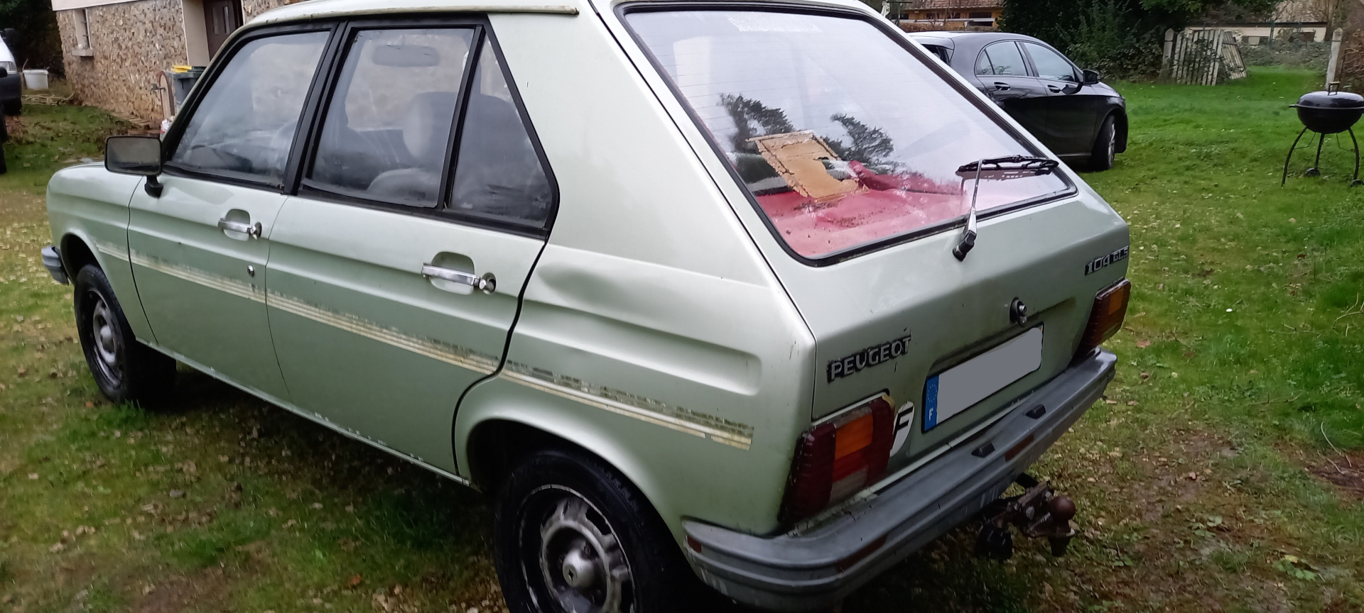 Zielony Peugeot widok 3/4 na lewy tył pojazdu